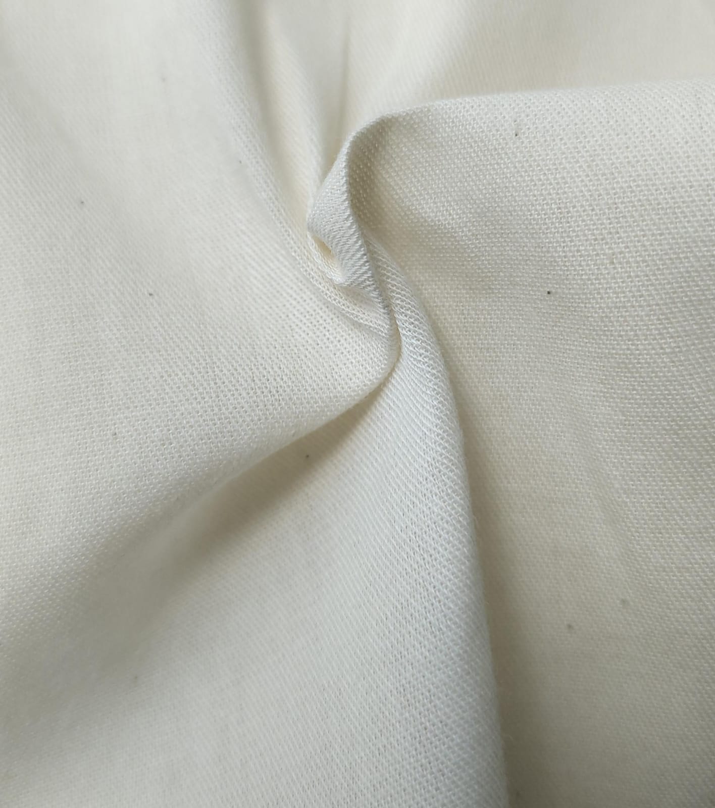 Close-up of soft, wrinkled pink cotton fabric displaying fine weave texture.