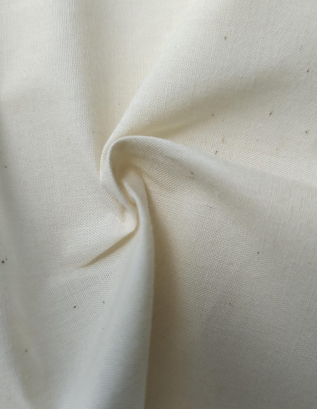Close-up of soft, wrinkled pink cotton fabric displaying fine weave texture.
