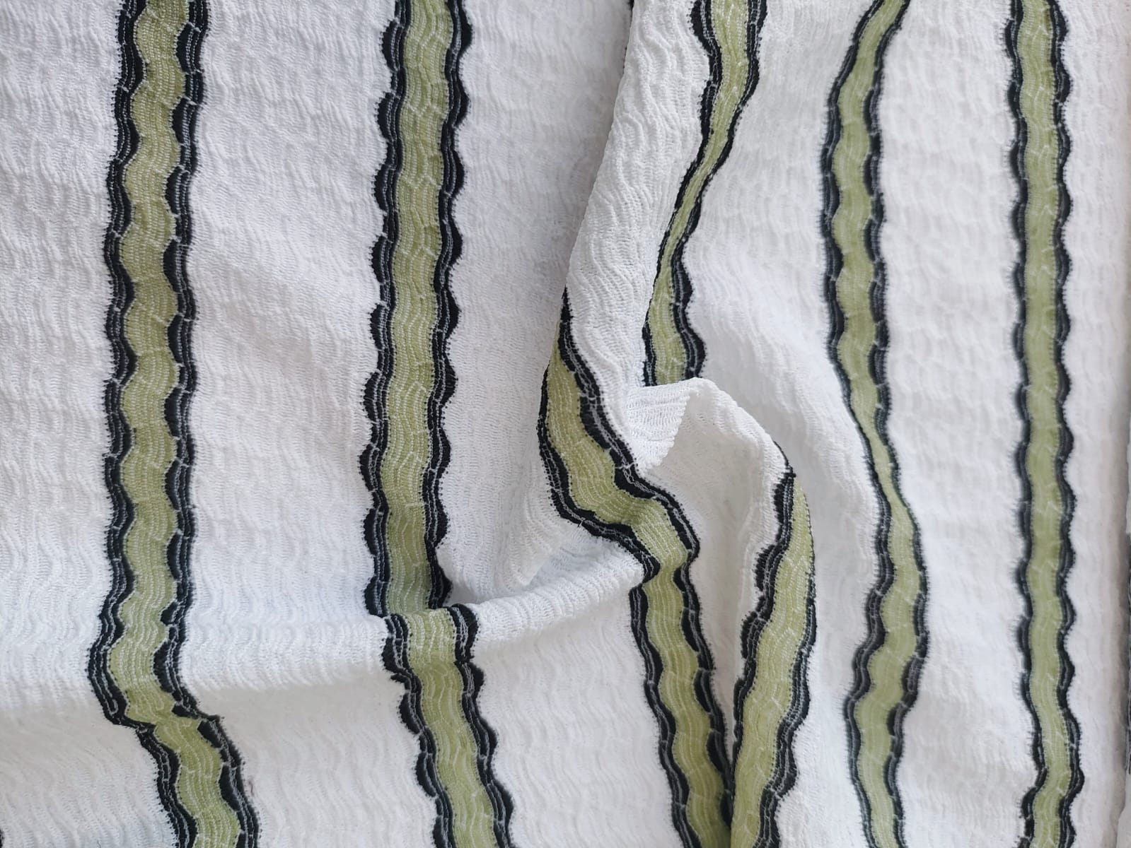 Close-up of soft, wrinkled pink cotton fabric displaying fine weave texture.