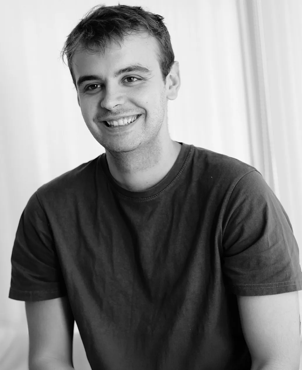 a black and white photo of ivan kirev smiling