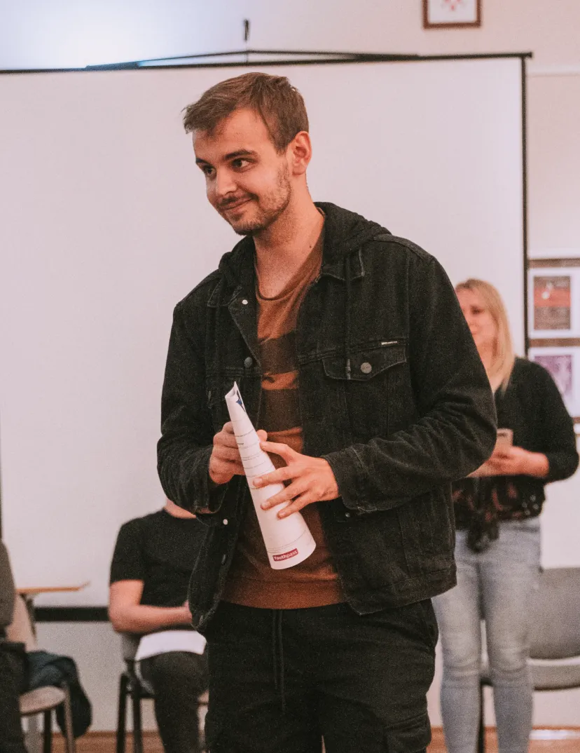 a photo of ivan kirev, speaking in front of a group of people