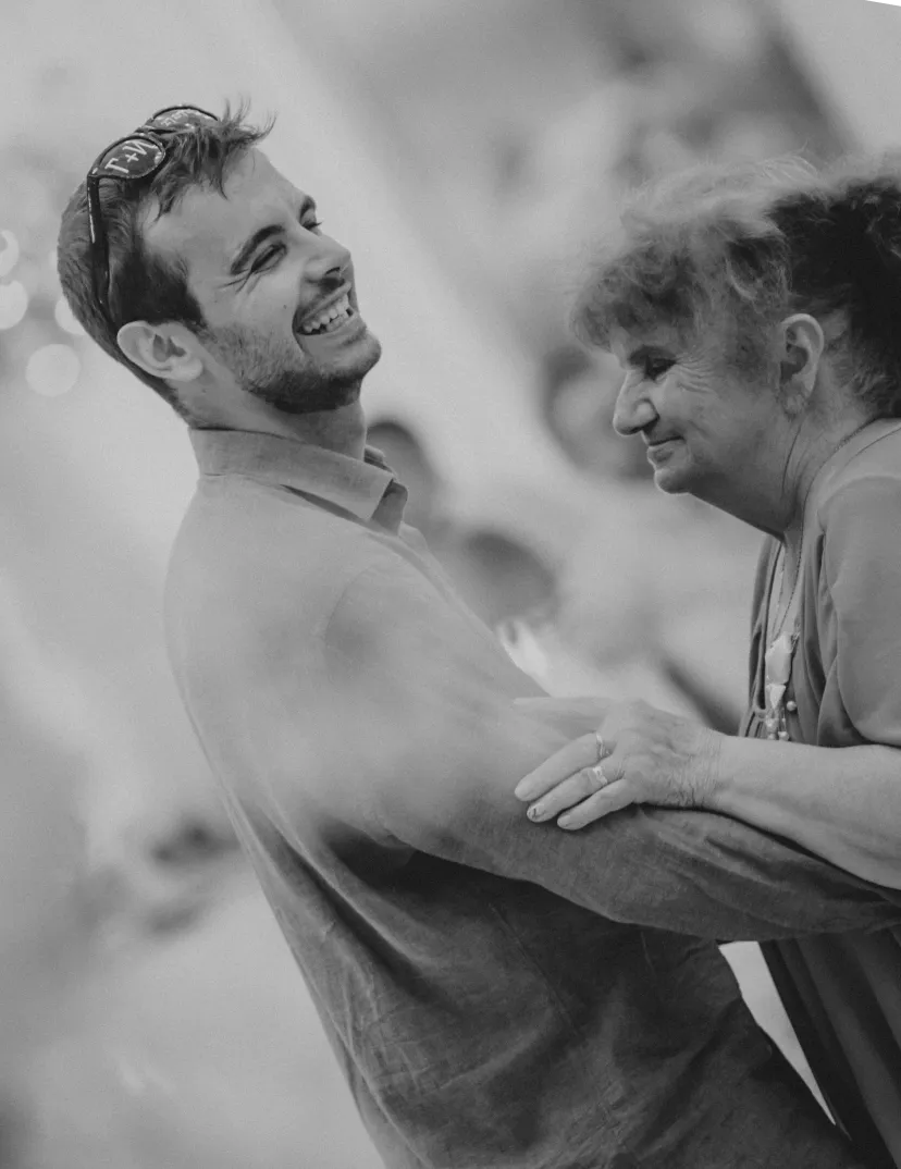 a black and white photo of ivan kirev dancing with his grandmother at his sister's wedding