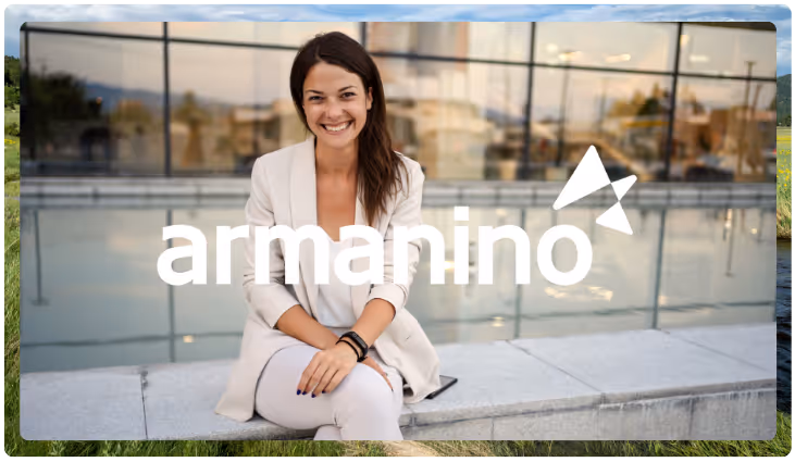 Smiling woman in light outfit sitting outdoors with glasses wall and urban background.