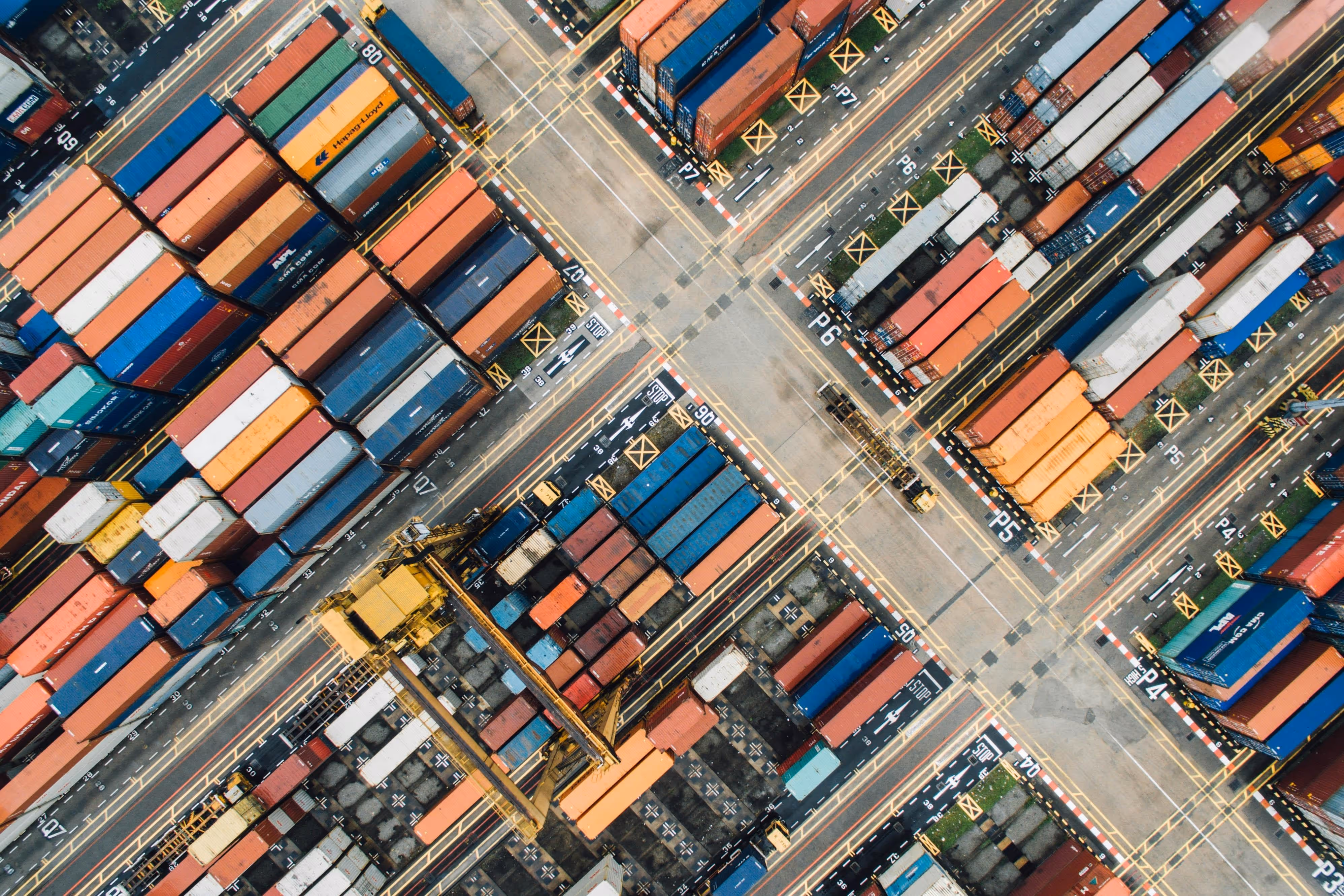 Container yard with rows of stacked shipping containers organized in a port facility.