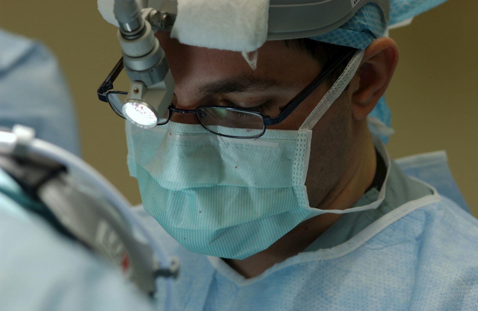 Surgeon wearing a surgical mask preparing for glaucoma eye surgery