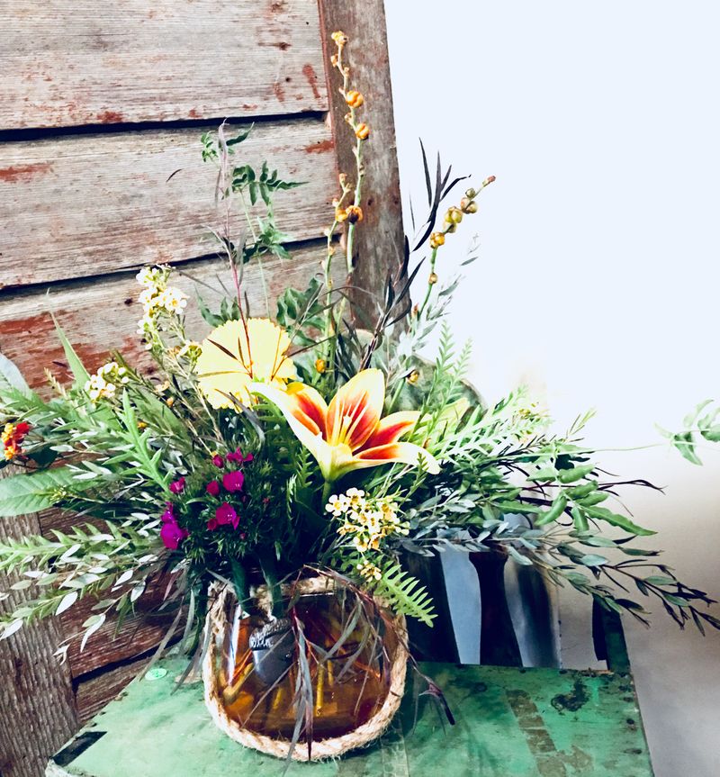 Rustic arrangement with orange lilies and purple accents