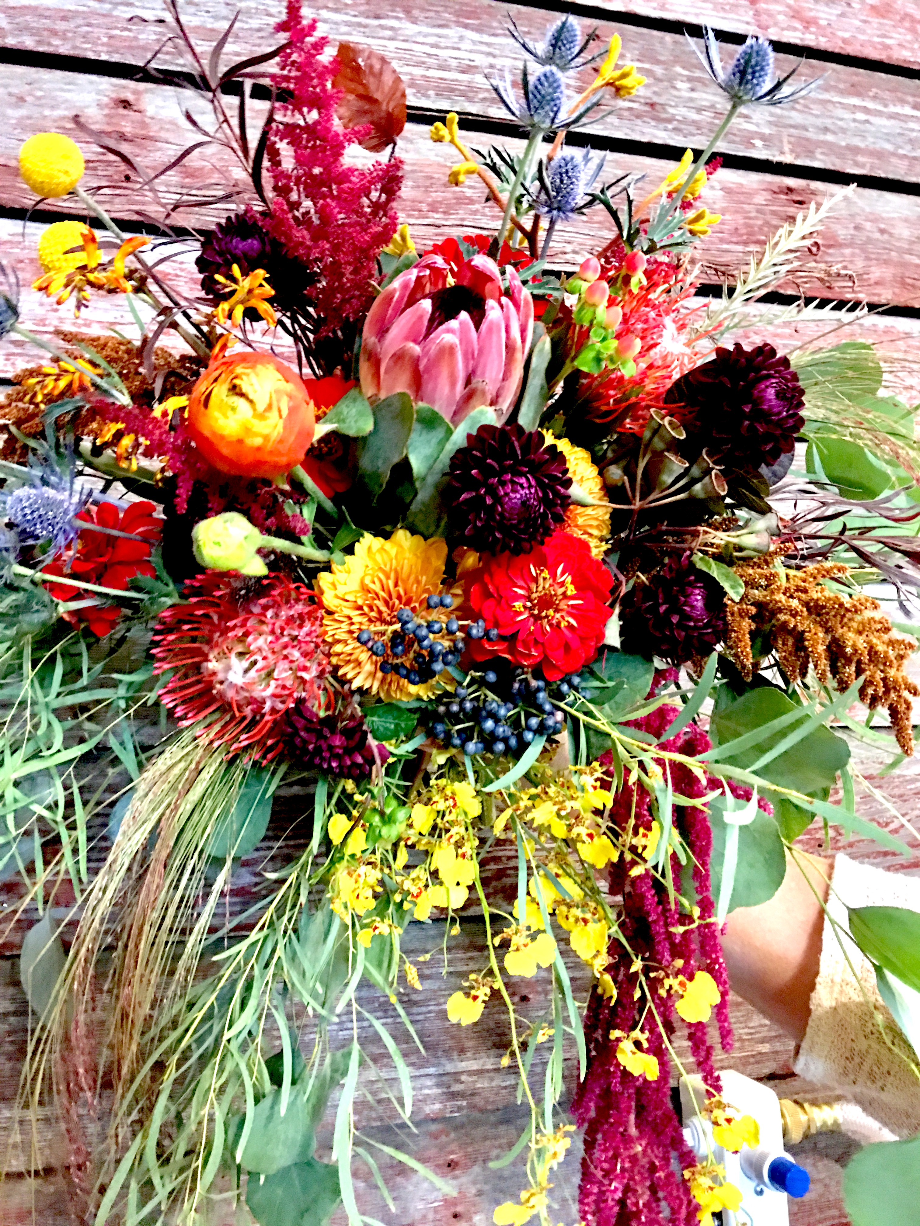 A tall colorful wildflower arrangement in a wood box, fresh from Simply Blooming