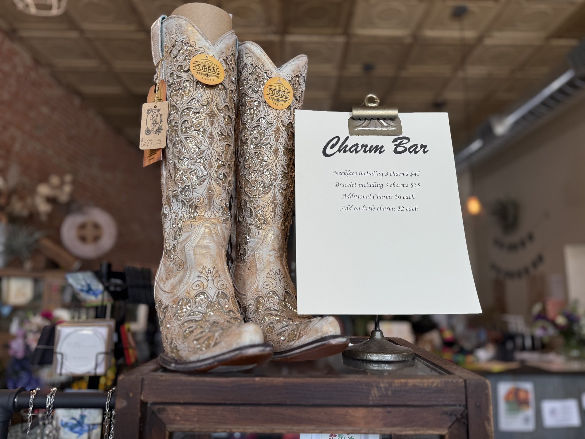 Cowboy boots and the charm bar sign inside Simply Blooming's western boutique