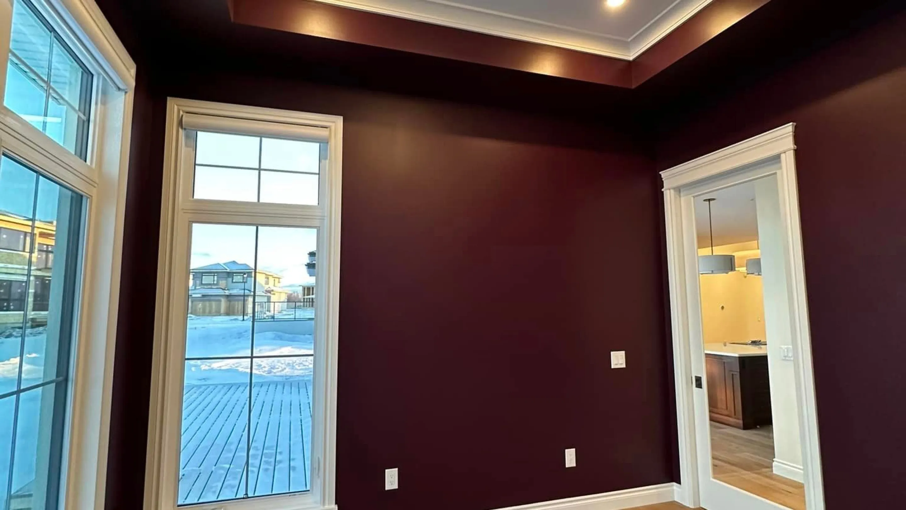 Empty room with dark purple walls, and white trim, painted by C&C Painting in Sherwood Park