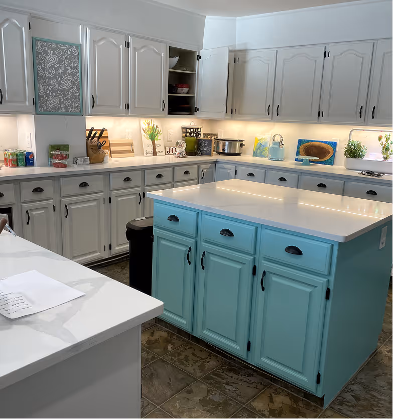 Bright kitchen with white cabinets and a blue island , painted by C&C Painting in St. Albert
