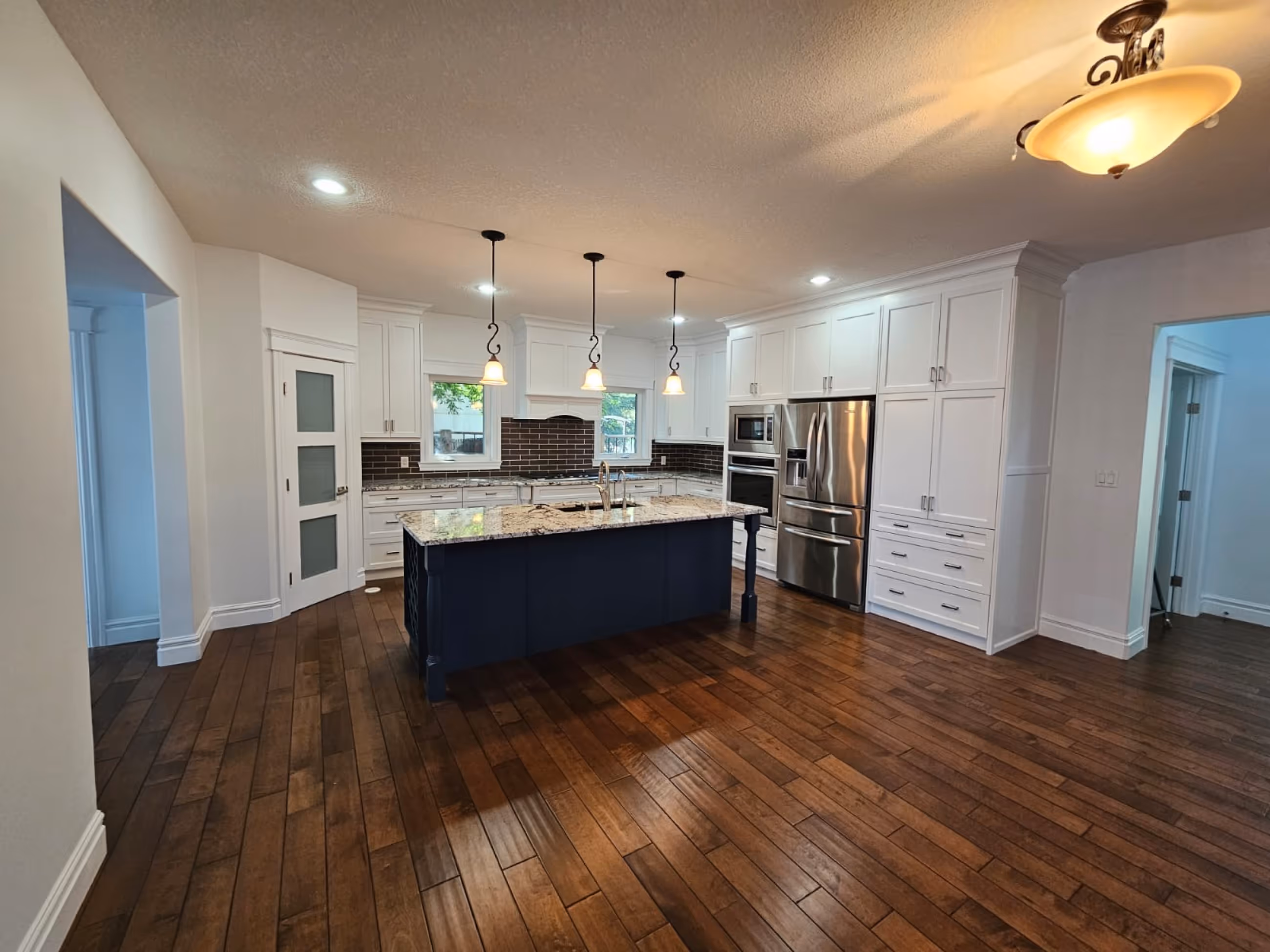 Modern kitchen with white cabinets, dark kitchen island, Painted by C&C Painting in Oakmont