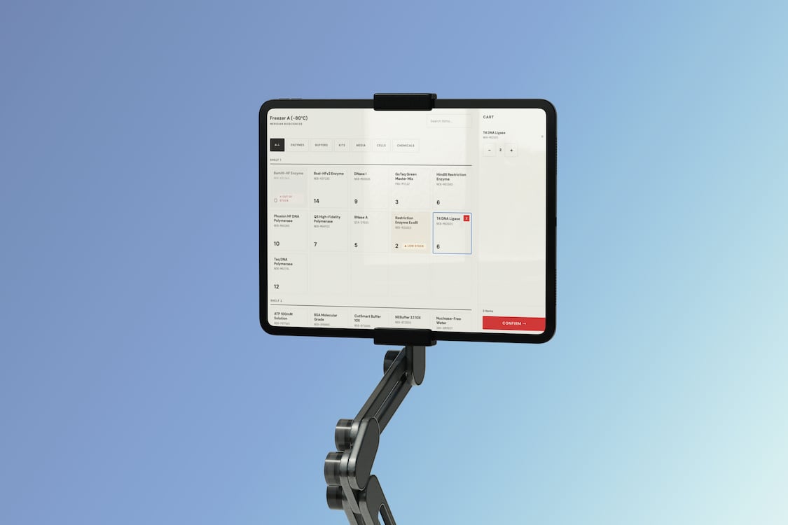 Tablet on adjustable arm displaying a digital inventory system for lab enzymes and chemicals with a confirmation button.