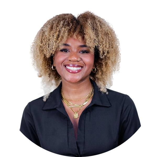 Smiling woman with curly blonde hair wearing a black shirt and gold necklaces and earrings.