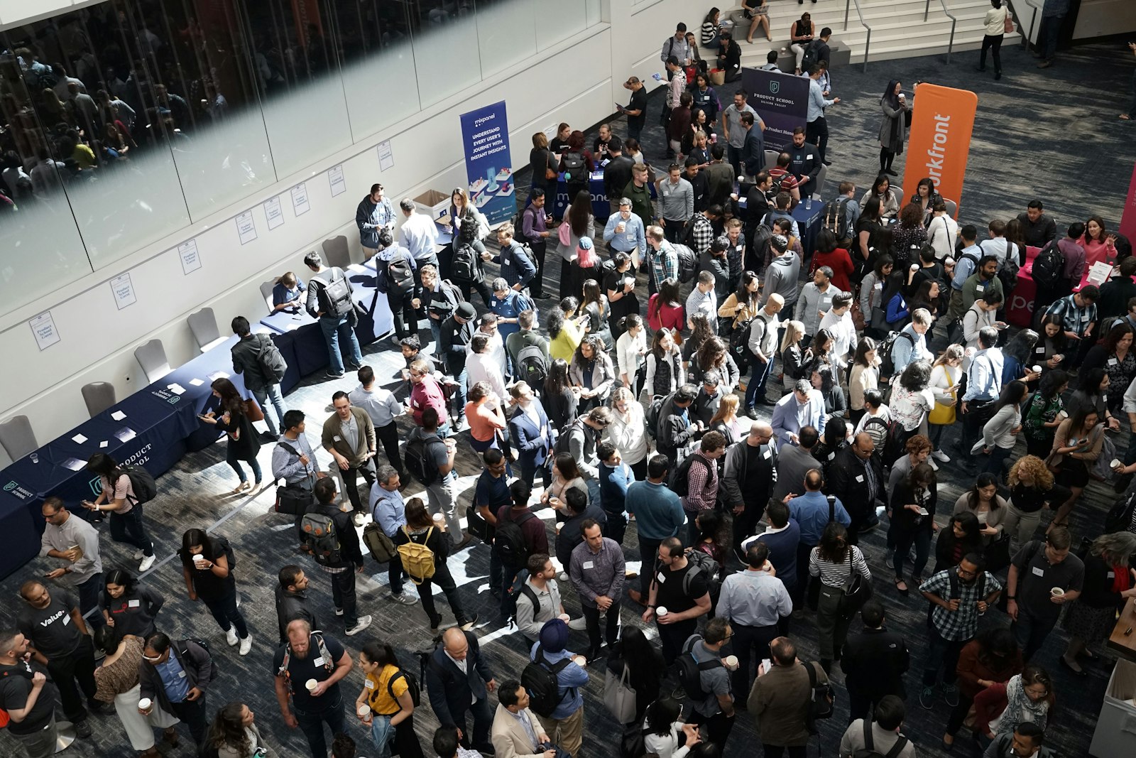 Attendees walking a busy exhibition hall