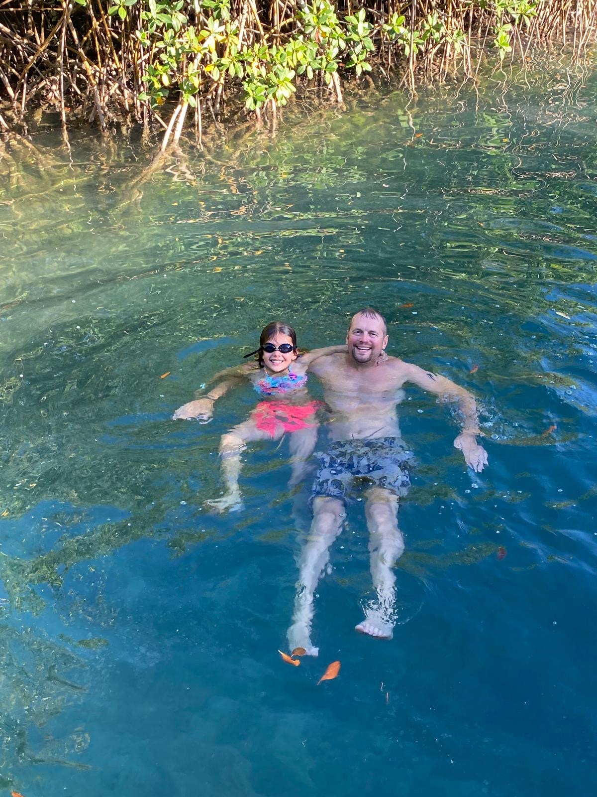 Family swimming in crystal clear water