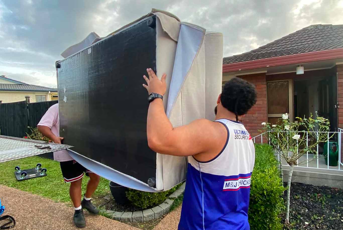 XMOVERS crew carefully wrapping and protecting a large appliance with blankets during furniture and large item delivery