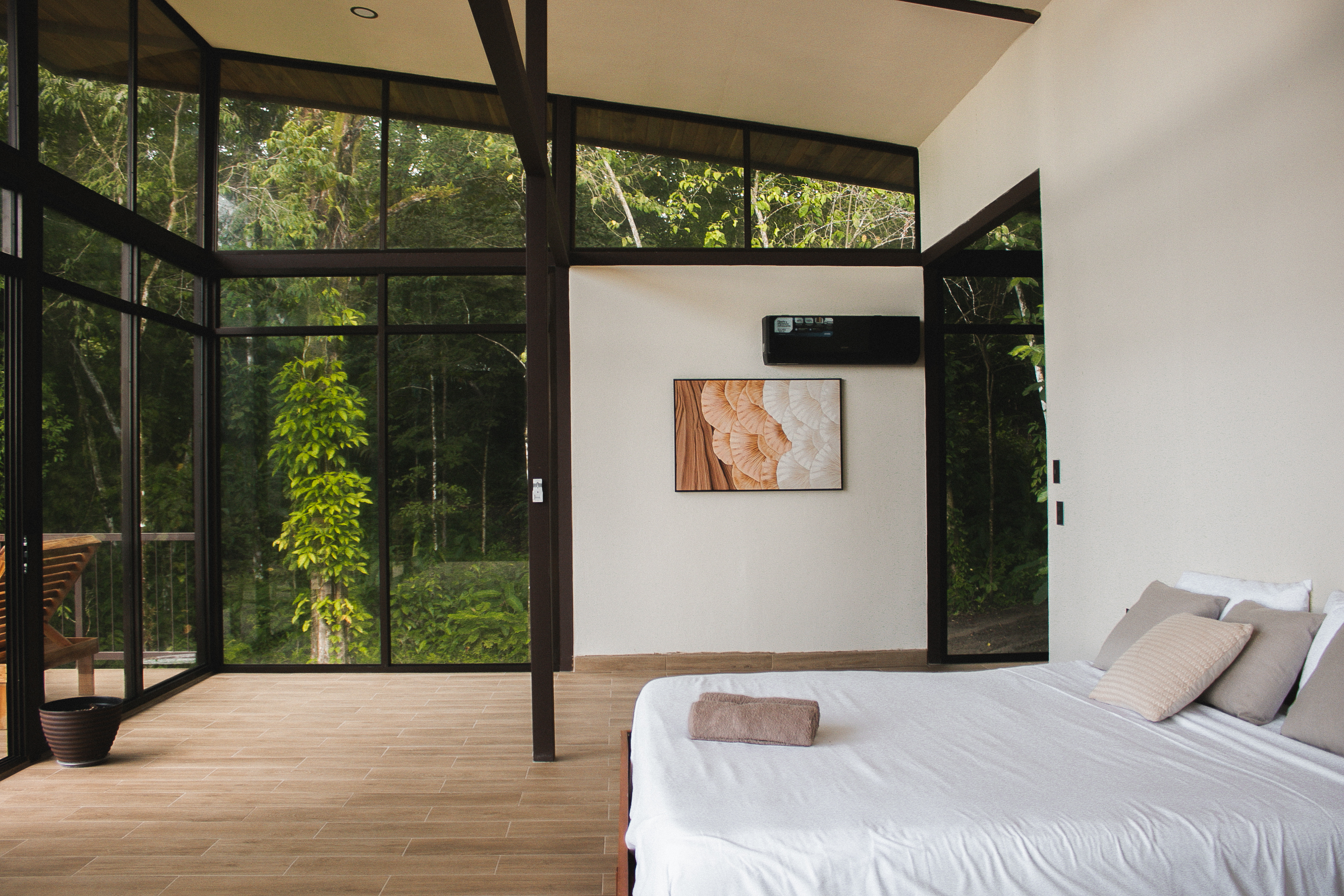 Bedroom with floor-to-ceiling glass opening onto the rainforest canopy, Costa Rica