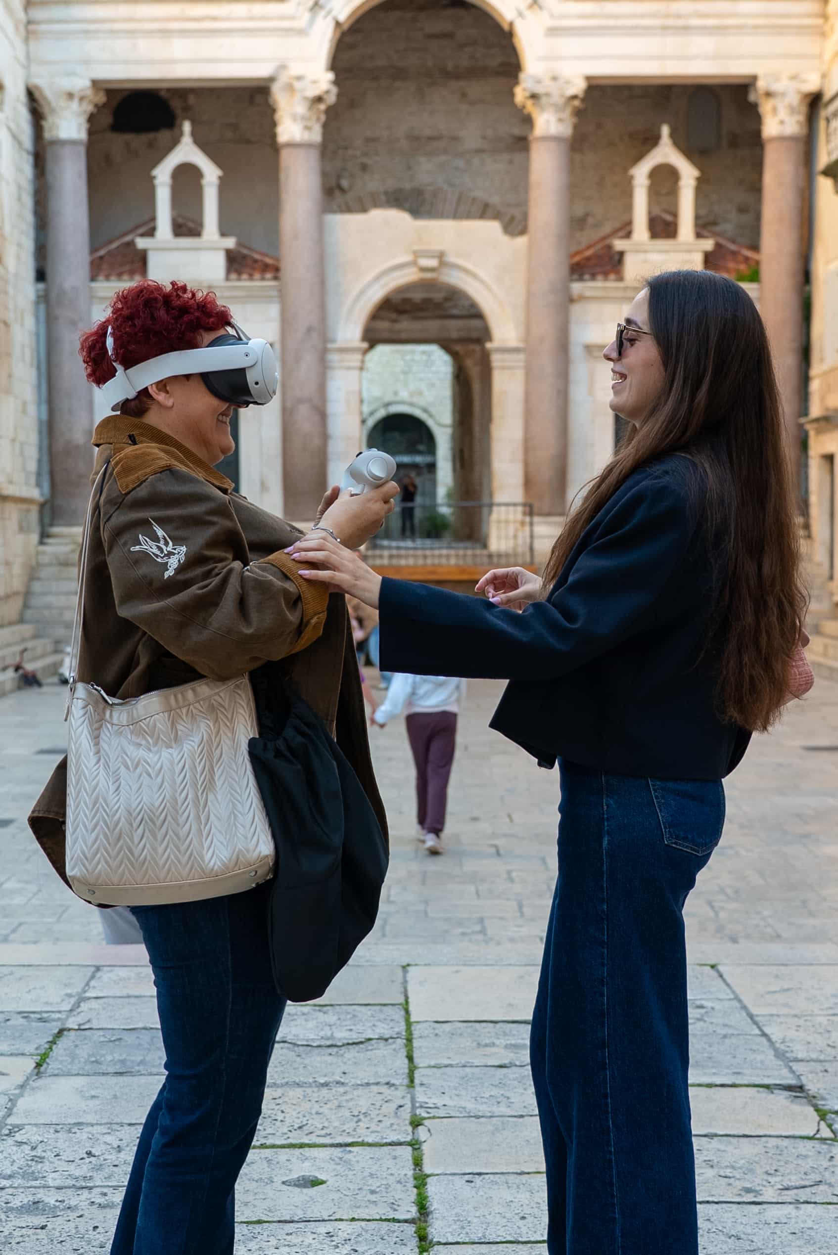 Time Walk vs Diocletian's Dream — visitor wearing Meta Quest 3 headset at Peristyle of Diocletian's Palace Split, with licensed guide, outdoor VR walking tour comparison