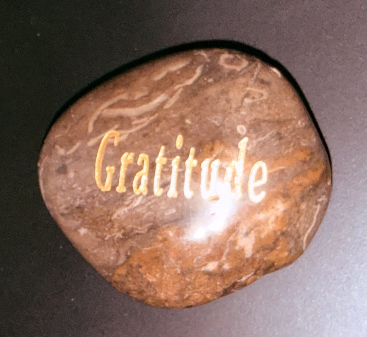A close-up gratitude stone used to symbolize reflection and well-being