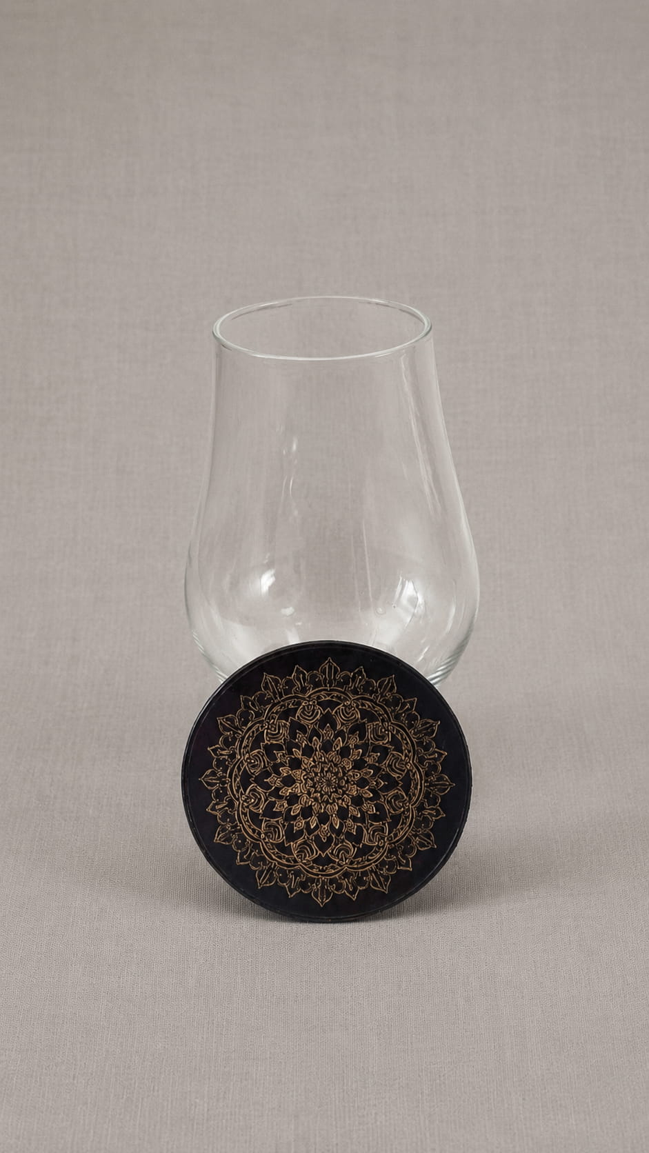 Black leather Glencairn topper with gold mandala engraving, leaning against a Glencairn whisky glass