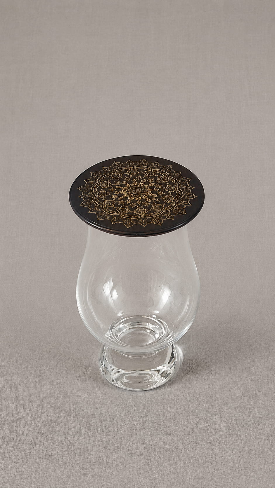 Black leather Glencairn topper with gold mandala engraving placed on top of a Glencairn whisky glass