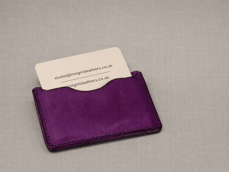 Purple leather business card holder open, showing an Insignis Leathers business card inside