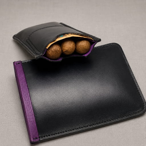 Black and purple leather cigar case open showing cigars inside, alongside the leather lid for the case