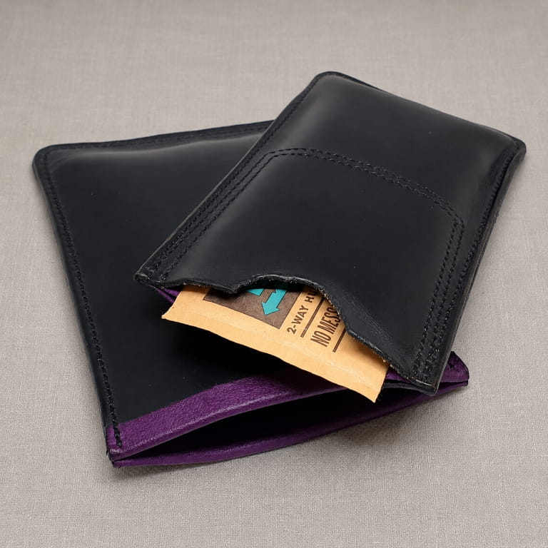 Black and purple leather cigar case empty showing humidification pouch pocket