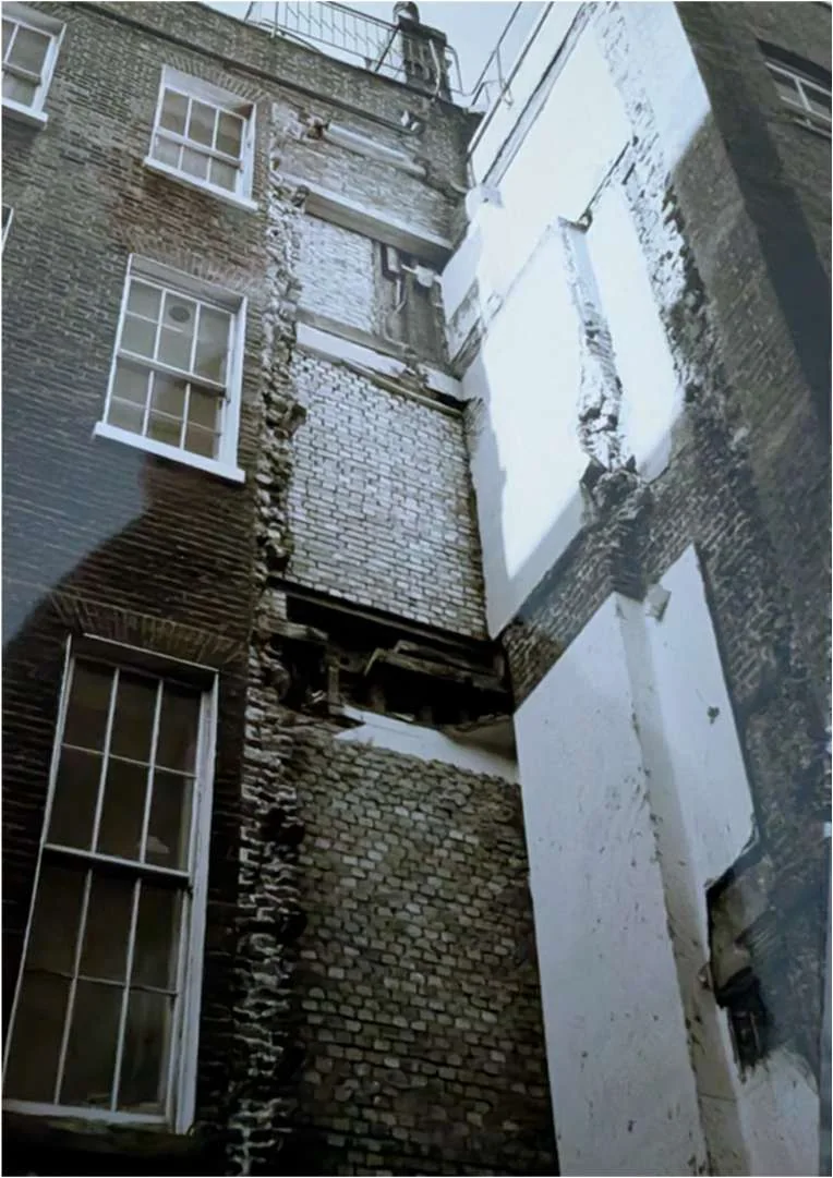 Historic photograph of the rear elevation during opening-up, showing exposed brickwork and timber