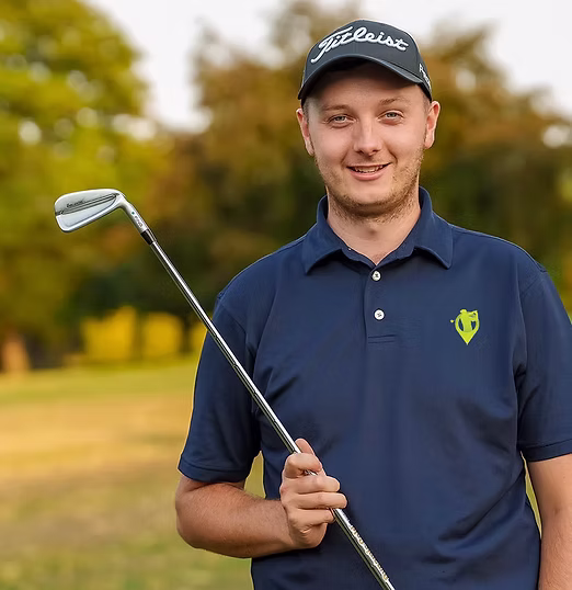 Connor Ashby, PGA Professional and Head of Player Development, holding an iron on the course