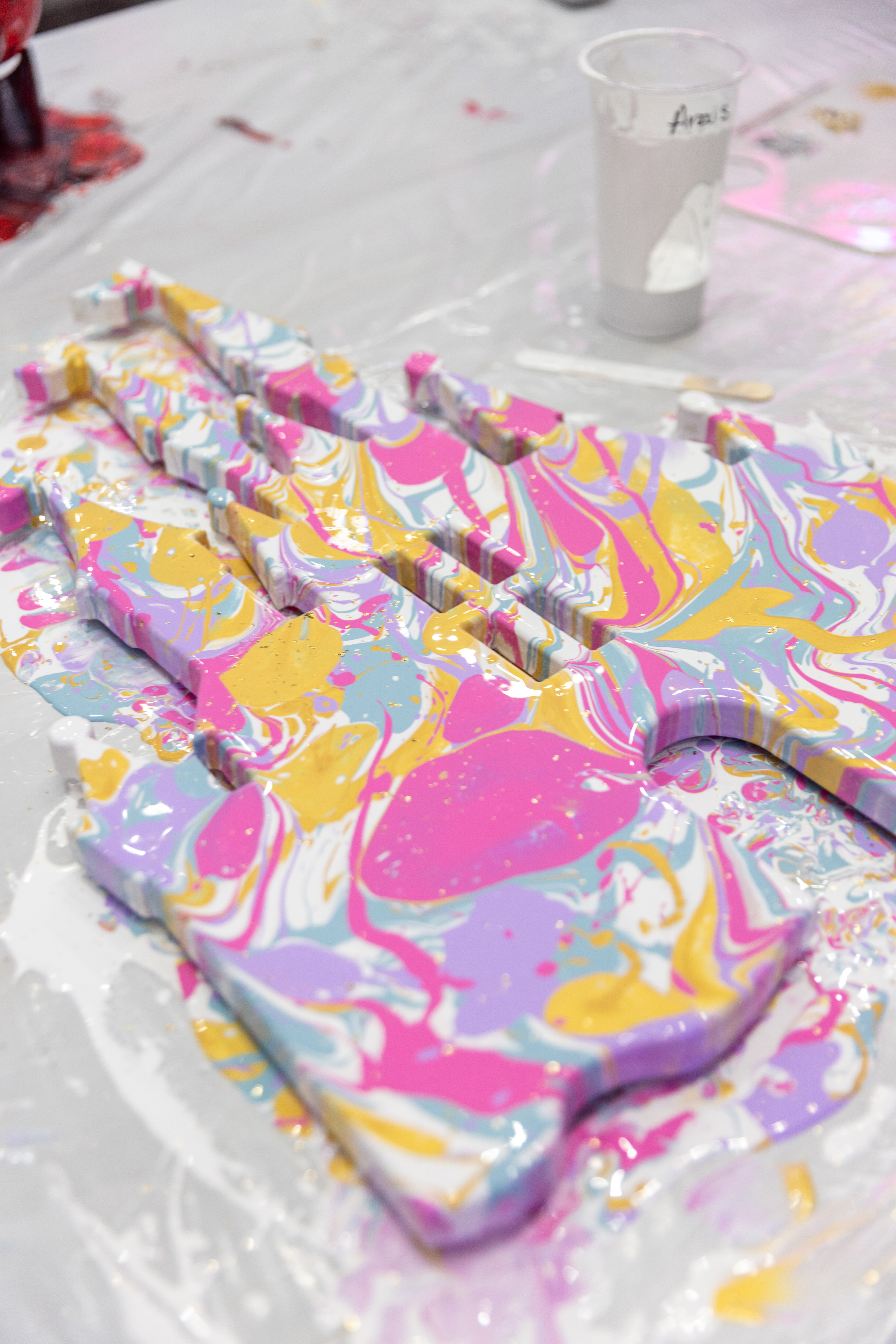Custom marbled lettering piece in pink, yellow, and purple