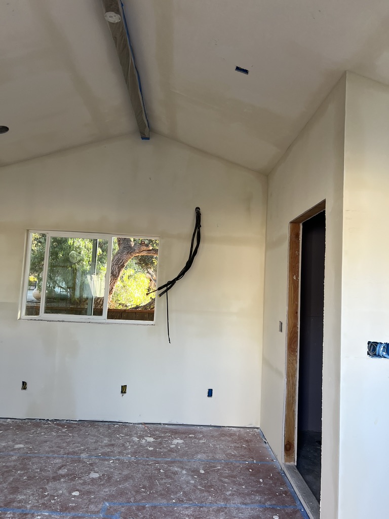 Drywall installation around an exposed ceiling beam in a Pismo Beach remodel