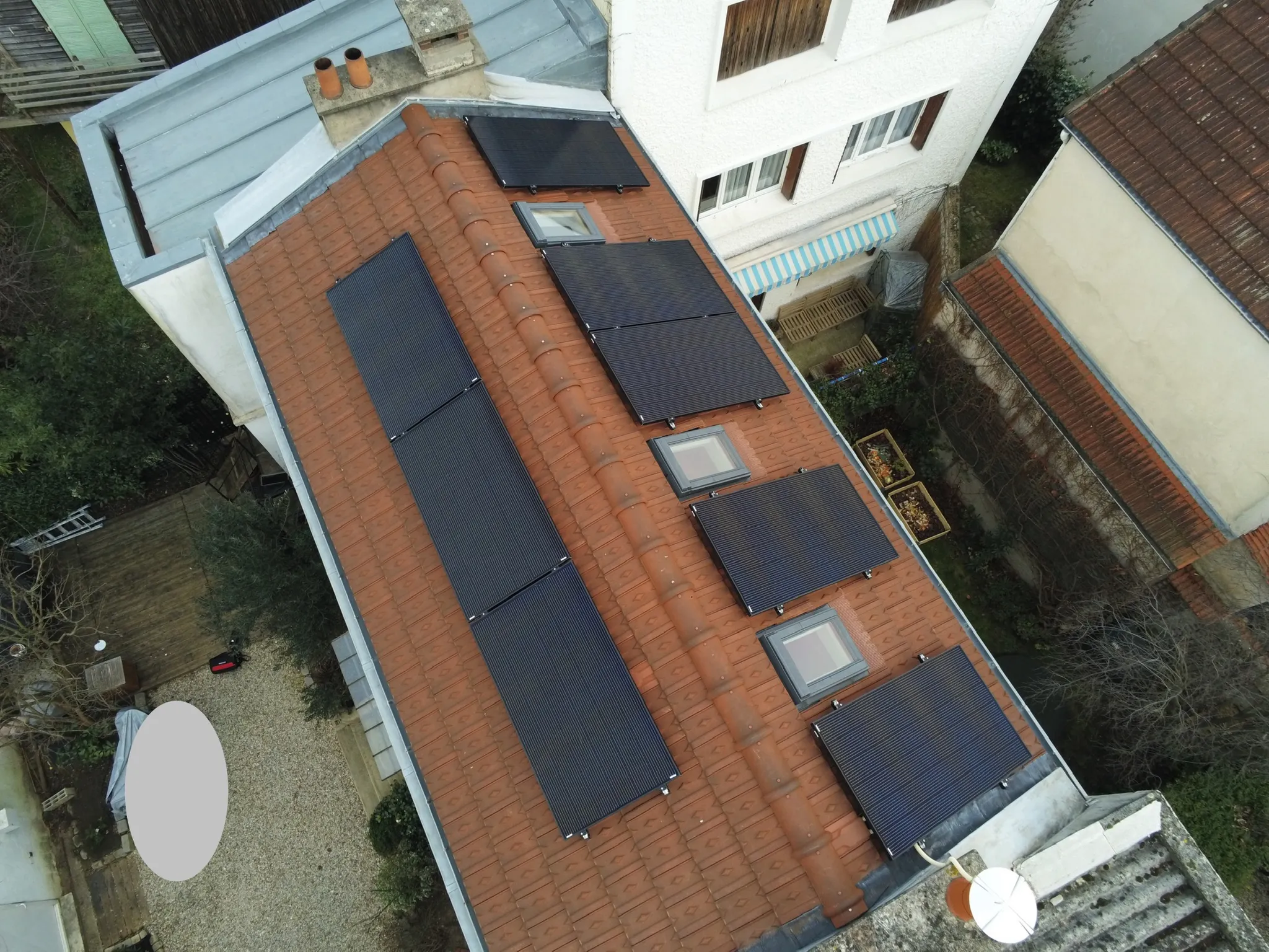 Vue aérienne de la toiture, les modules répartis en plusieurs groupes entre les fenêtres de toit, Asnières-sur-Seine (92600)