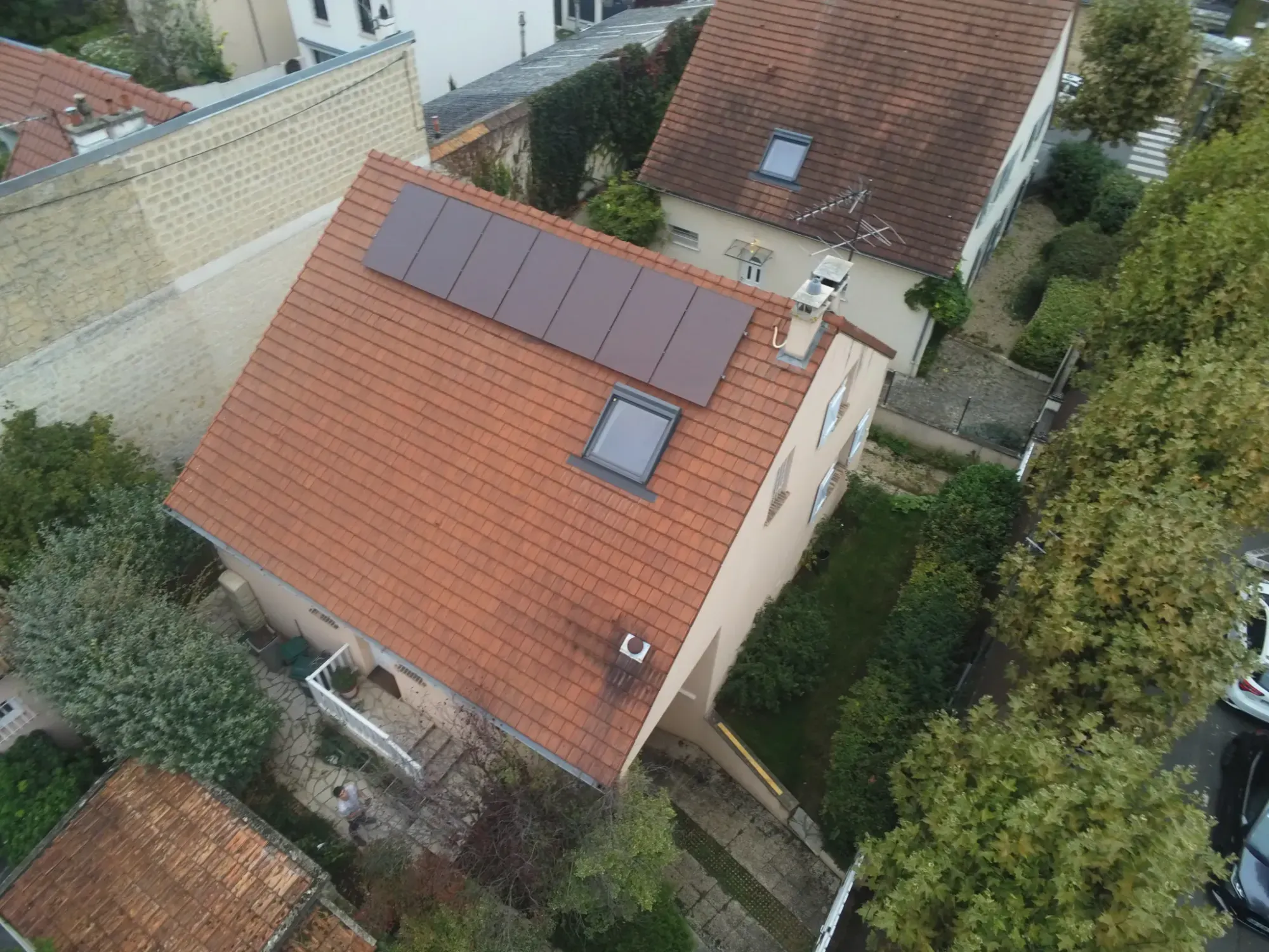 Vue aérienne de la maison, les modules sur le pan de toiture en tuiles mécaniques, à Maisons-Laffitte (78600)