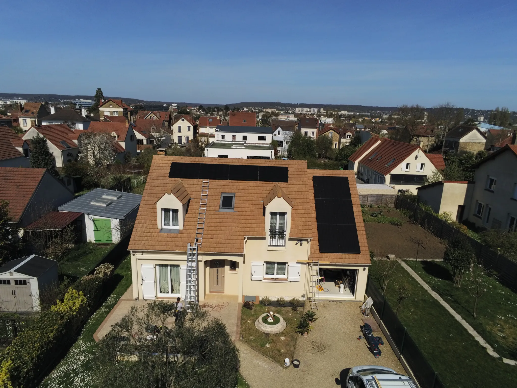 Vue aérienne large de la maison et de ses dix modules dans le quartier, à Sannois (95110)