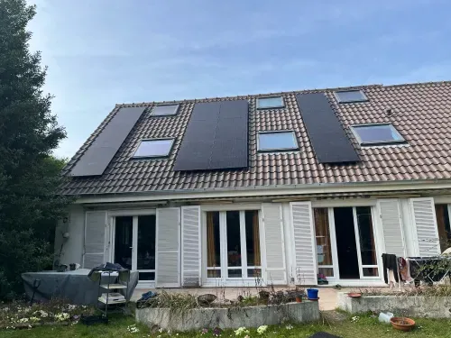 La maison vue du jardin, les douze modules répartis entre les fenêtres de toit, à Plaisir (78370)