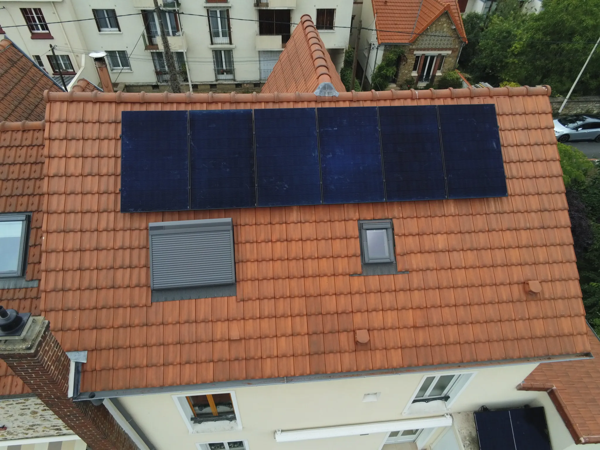 Les six modules alignés sur la toiture en tuiles mécaniques, vus du ciel, à Houilles (78800)