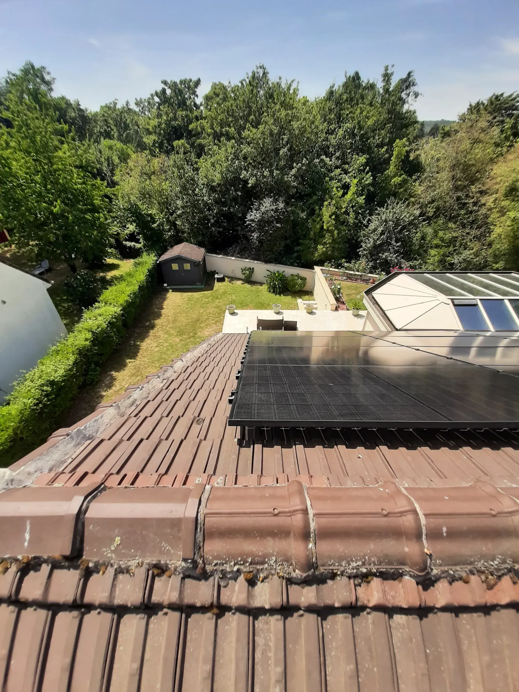 Vue plongeante sur les modules photovoltaïques posés sur la toiture en tuiles mécaniques, à Longjumeau (91)