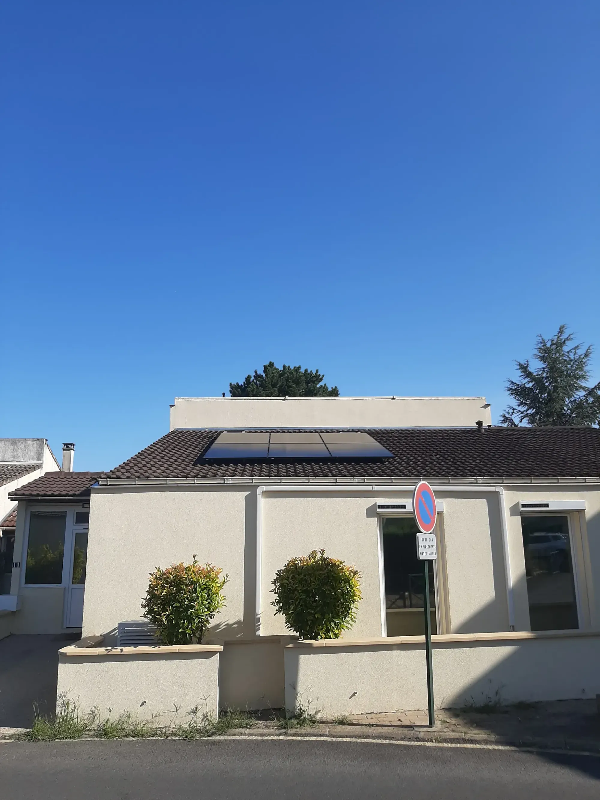 Vue d'ensemble de la maison et de sa toiture en tuiles béton équipée de six modules photovoltaïques, aux Clayes-sous-Bois (78)
