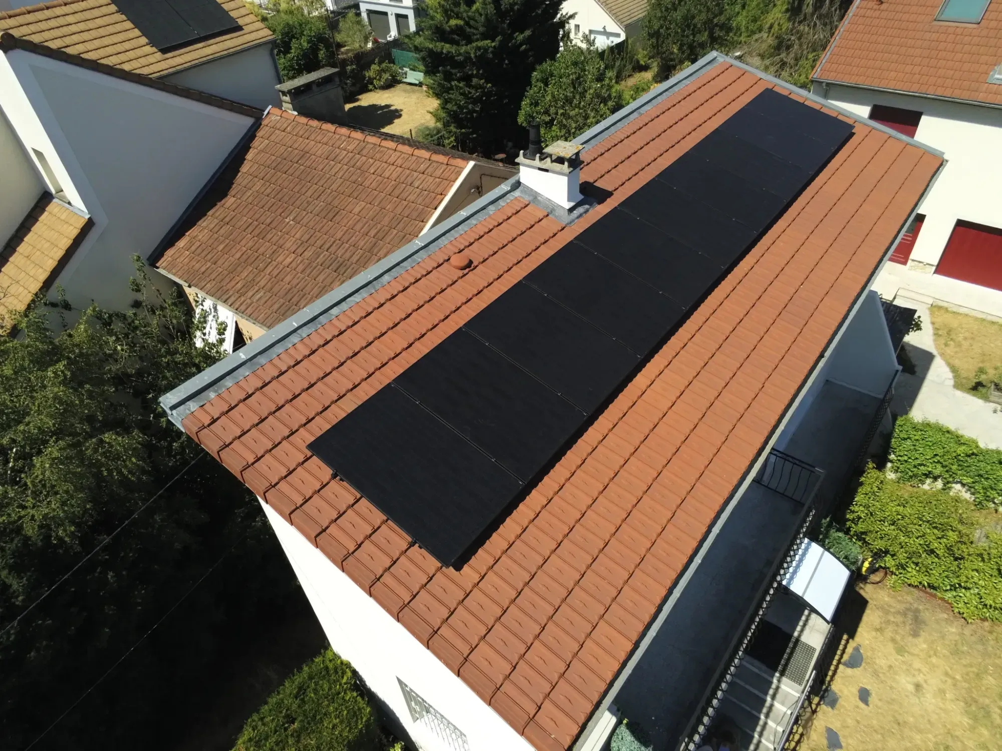 Vue aérienne de la maison et de ses dix modules photovoltaïques sur la toiture en tuiles mécaniques, à Sartrouville (78)