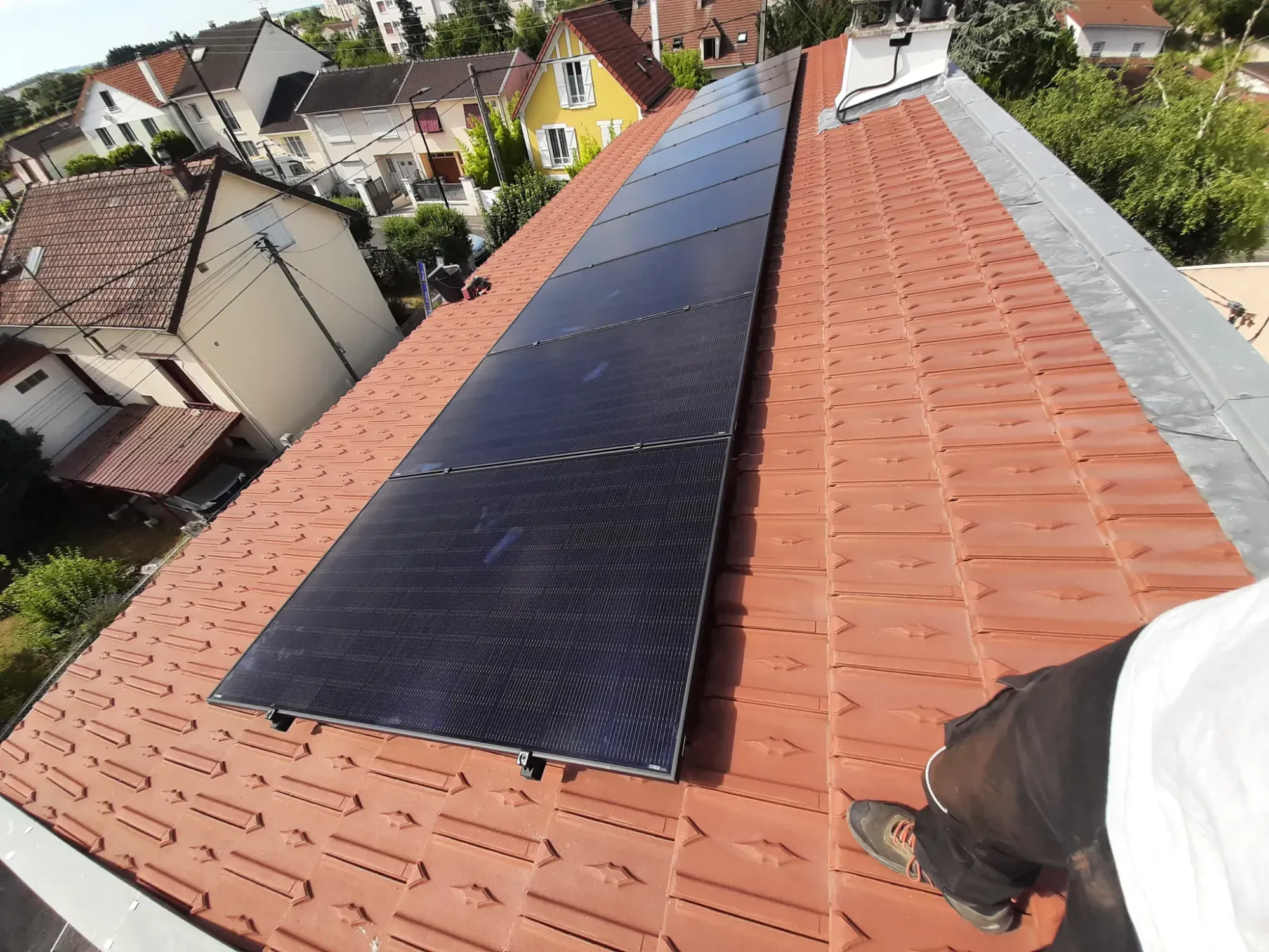 Modules photovoltaïques sur la toiture en tuiles mécaniques, vus depuis le toit pendant le chantier, à Sartrouville (78)