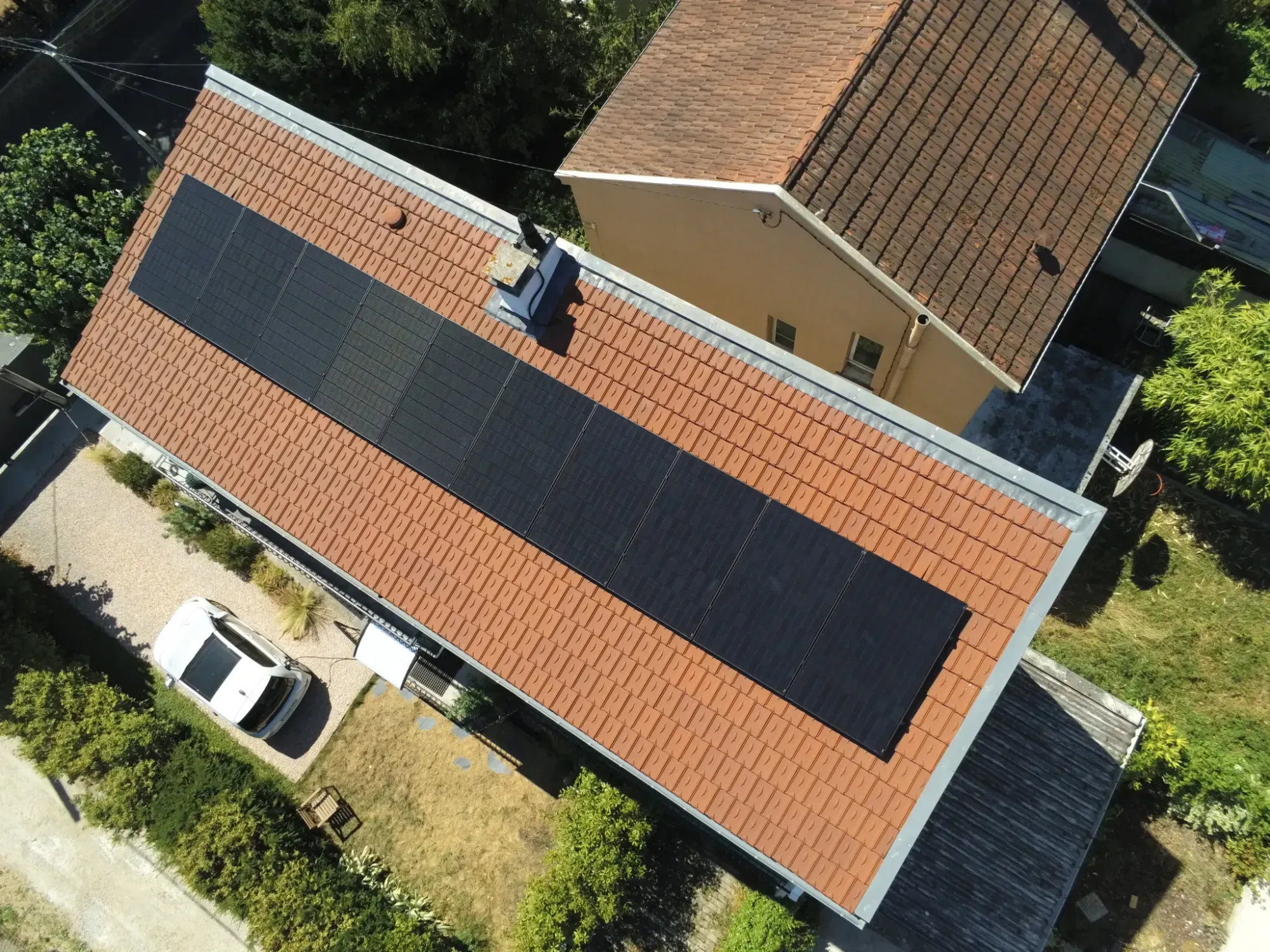Vue du dessus de la rangée de dix modules photovoltaïques Voltec Solar sur la toiture en tuiles mécaniques, à Sartrouville (78)