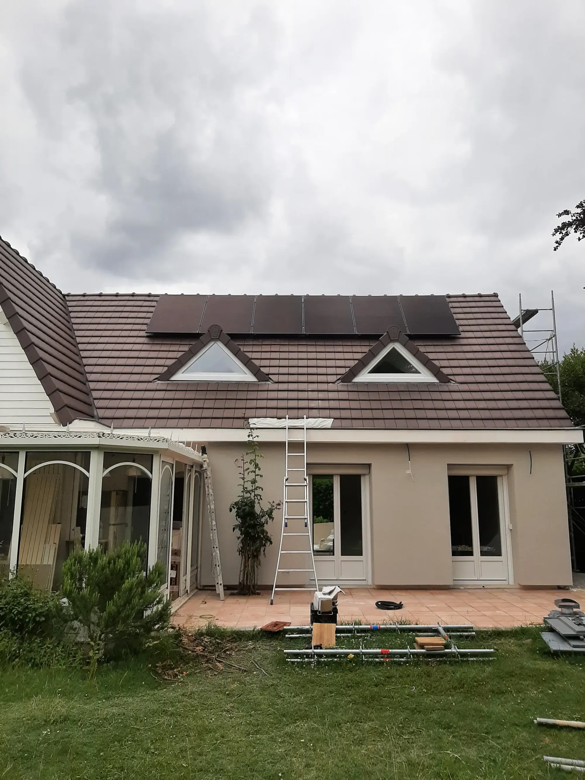 La maison vue du jardin, avec les six modules photovoltaïques au-dessus des deux lucarnes, à Croissy-sur-Seine (78)