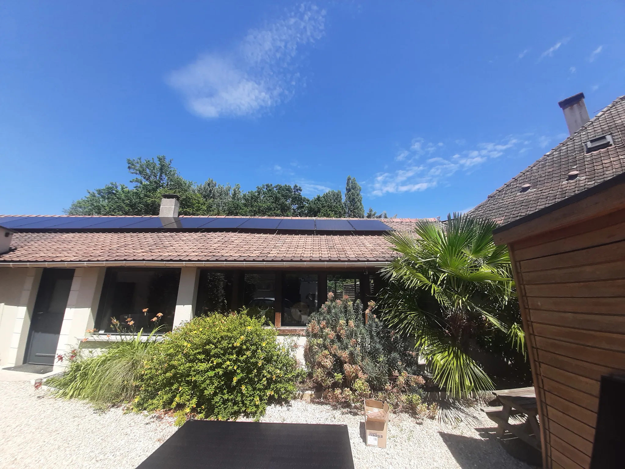 La maison vue de la cour : les modules restent à peine visibles au-dessus de la toiture en tuiles, à Briis-sous-Forges (91)