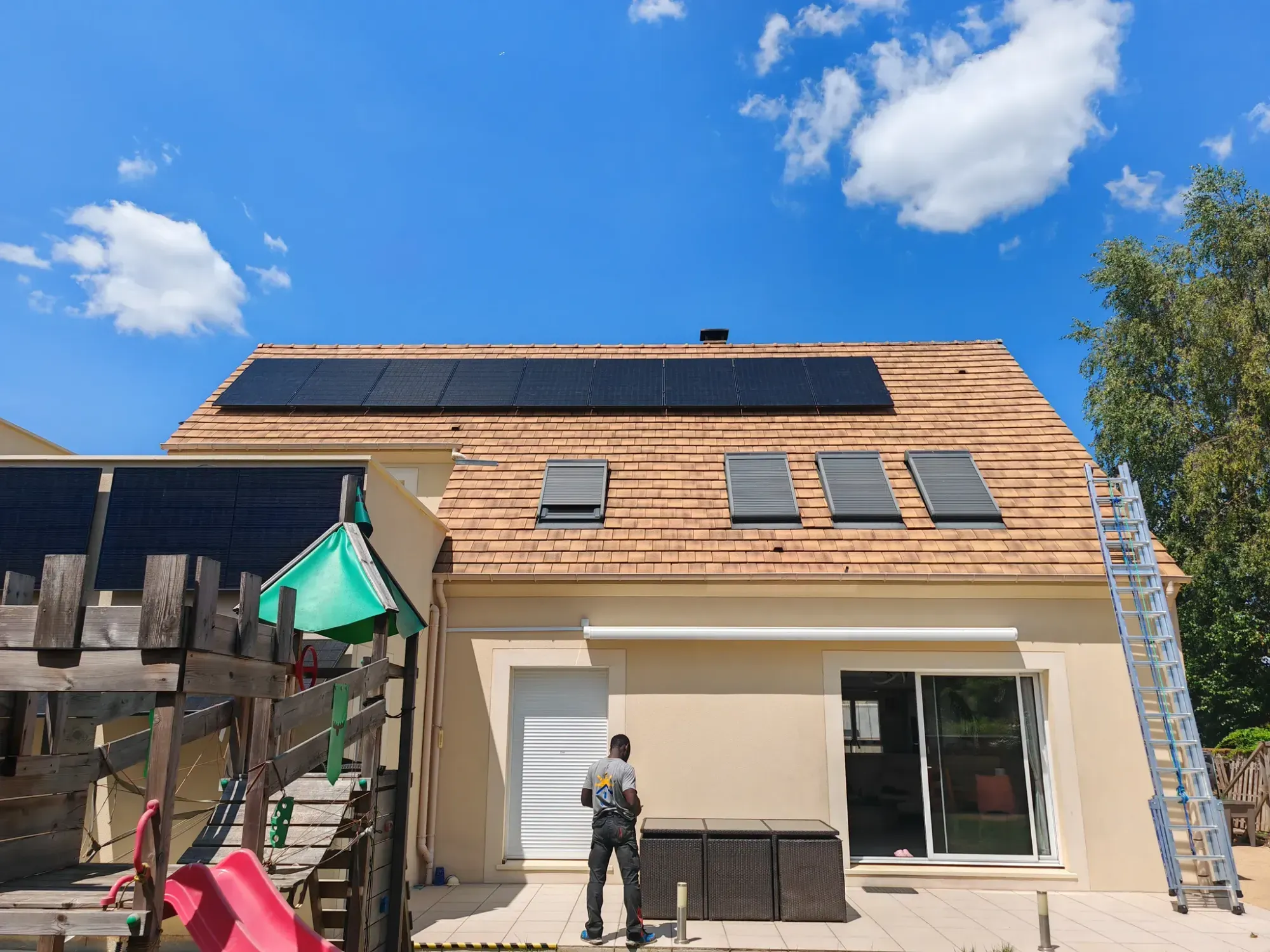 La maison vue du jardin, avec ses modules photovoltaïques en haut de la toiture, à Dourdan (91)