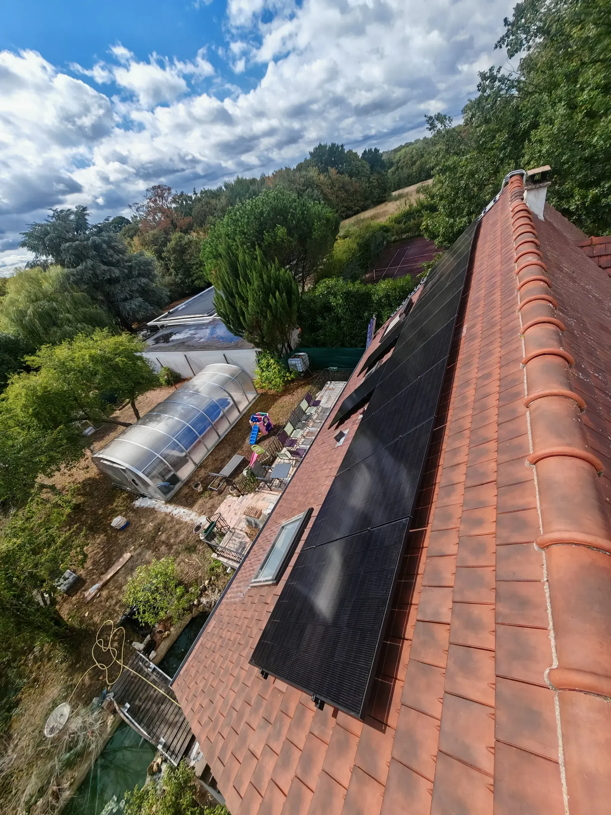 Les modules photovoltaïques vus depuis le faîtage, sur les tuiles mécaniques anciennes, à Boissettes (77)