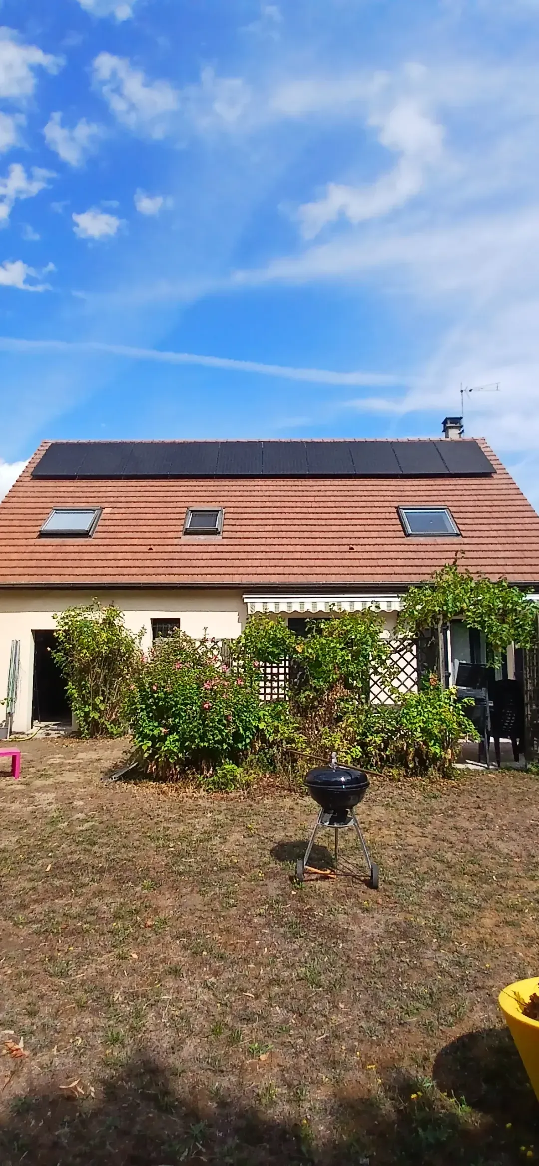 La maison vue du jardin, avec ses dix modules en une rangée sur le pan arrière en tuiles mécaniques, à Conflans-Sainte-Honorine (78)