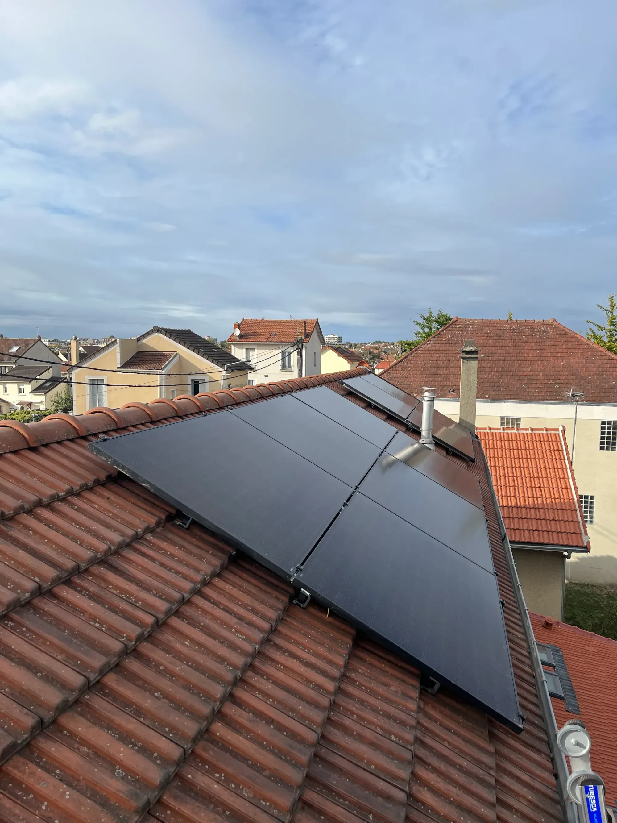 Modules Voltec Solar posés sur le pan en tuiles mécaniques, à côté de la sortie de toit, à Houilles (78)