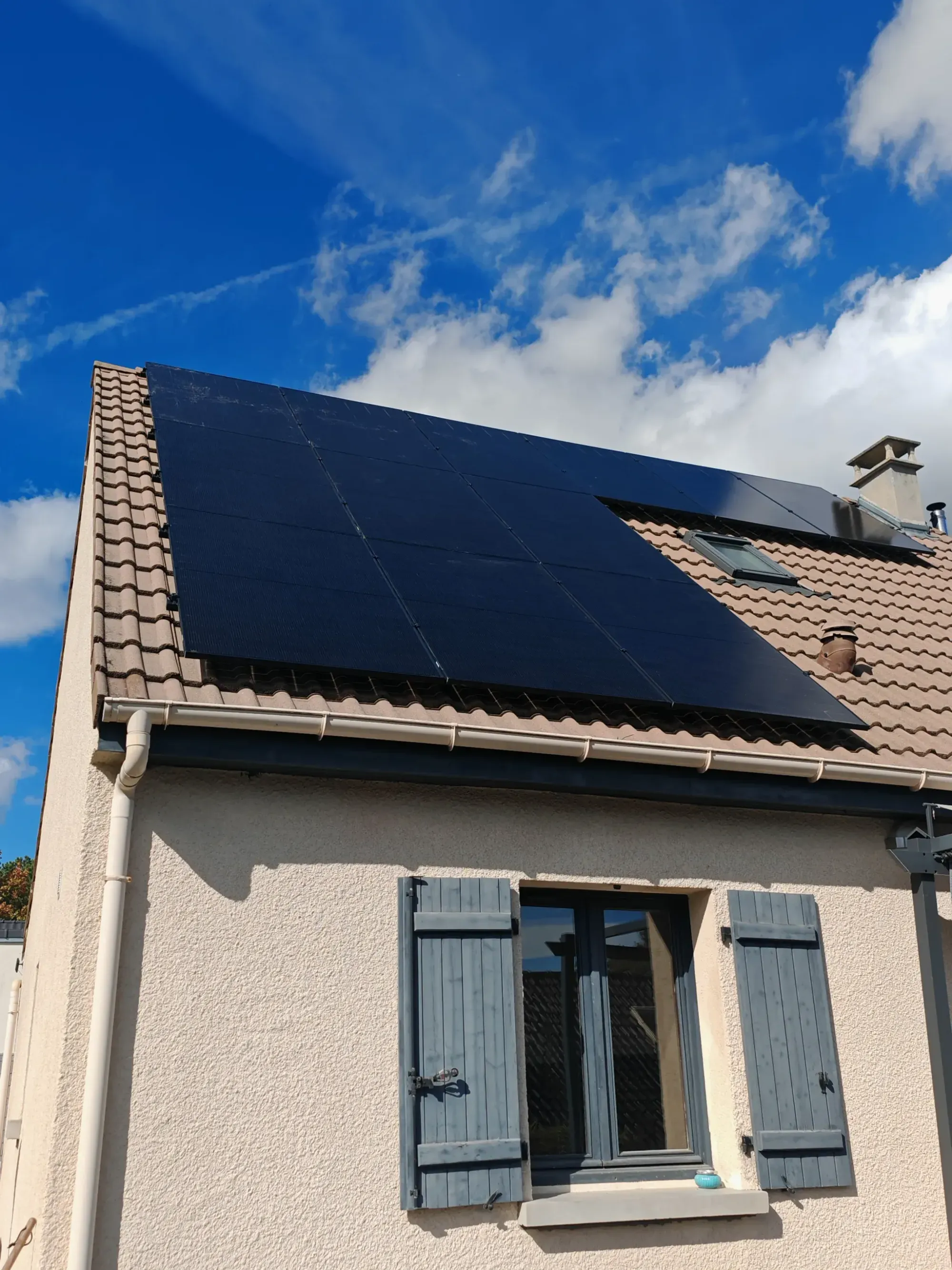 Façade de la maison et ses modules photovoltaïques autour de la fenêtre de toit, à Annet-sur-Marne (77)