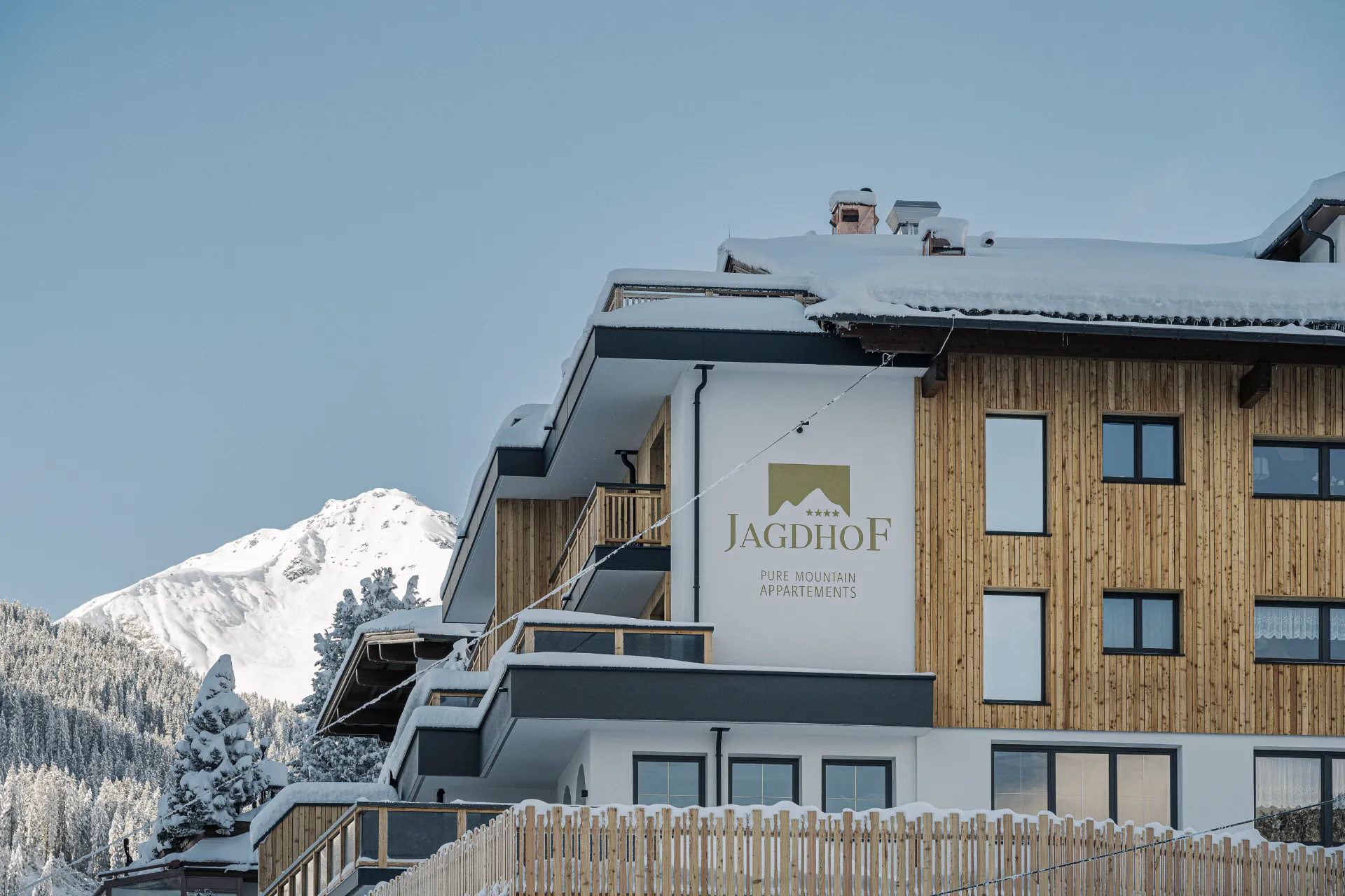 Der Jagdhof im Schnee vor tiefblauem Winterhimmel